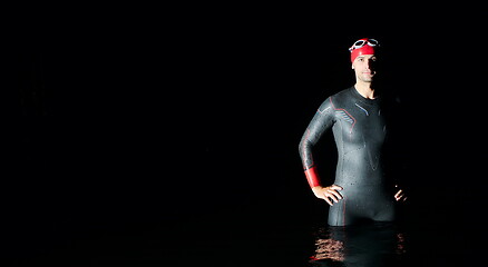 Image showing authentic triathlete swimmer having a break during hard training on night