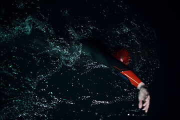 Image showing real triathlon athlete swimming in dark night