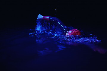 Image showing real triathlon athlete swimming in dark night