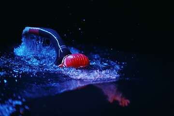 Image showing real triathlon athlete swimming in dark night