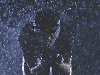 Image showing triathlon athlete riding bike on rainy night