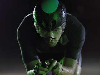Image showing triathlon athlete riding bike at night