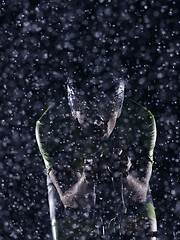 Image showing triathlon athlete riding bike on rainy night