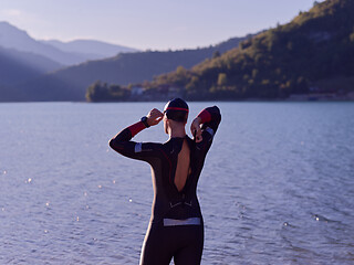 Image showing authentic triathlon athlete getting ready for swimming training on lake