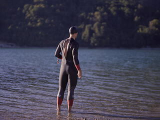 Image showing triathlete swimmer portrait wearing wetsuit on training