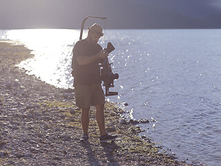 Image showing videographer taking action shot of triathlon swimming athlete