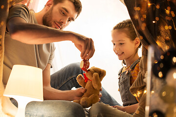 Image showing happy family playing with toy in kids tent at home