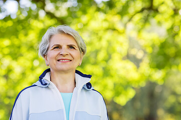 Image showing smiling sporty senior woman at summer park