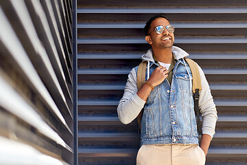 Image showing smiling indian man with backpack on city street