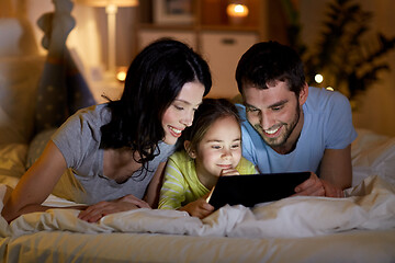 Image showing family with tablet pc in bed at night at home