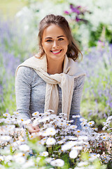 Image showing young woman with flowers at summer garden