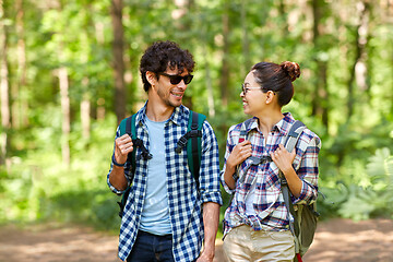 Image showing mixed race couple with backpacks hiking in forest