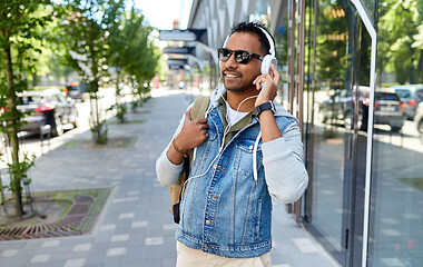 Image showing indian man in headphones with backpack in city