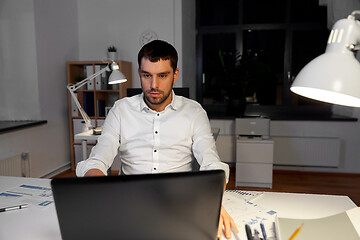 Image showing businessman with laptop working at night office