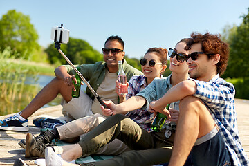 Image showing friends with drinks taking selfie on lake pier