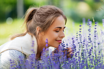 Image showing young woman smelling lavender flowers in garden