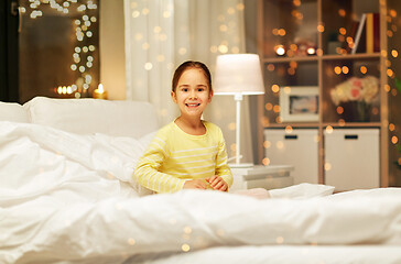 Image showing happy little girl in bed at home at night