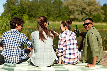 Image showing friends drinking beer and cider on lake pier