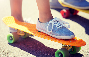 Image showing close up of female feet riding short skateboard