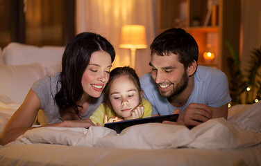 Image showing family with tablet pc in bed at night at home