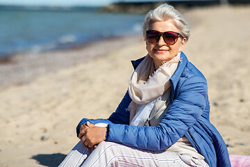 Image showing happy senior woman in jacket on beach