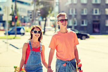 Image showing teenage couple with skateboards on city street