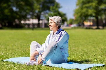 Image showing happy senior woman exercising at summer park