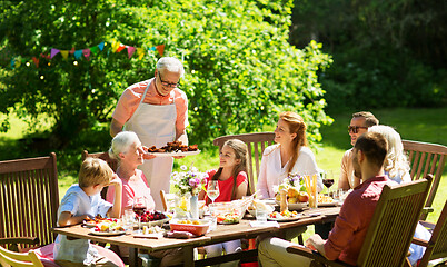 Image showing family having dinner or barbecue at summer garden