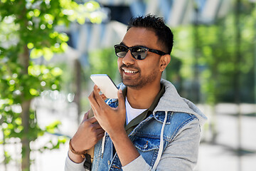 Image showing man recorving voice message on smartphone in city