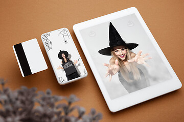 Image showing Young woman in hat as a witch on device screen background, mock up with copyspace