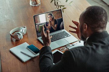 Image showing Man working from home, remote office concept. Young businessman, manager doing tasks with laptop, has online conference.