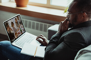 Image showing Man working from home, remote office concept. Young businessman, manager doing tasks with laptop, has online conference.