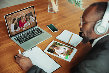 Image showing Man working from home, remote office concept. Young businessman, manager doing tasks with laptop, has online conference.