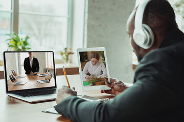 Image showing Man working from home, remote office concept. Young businessman, manager doing tasks with laptop, has online conference.