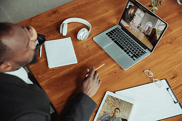 Image showing Man working from home, remote office concept. Young businessman, manager doing tasks with laptop, has online conference.