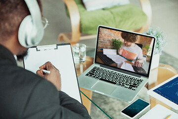 Image showing Man working from home, remote office concept. Young businessman, manager doing tasks with laptop, has online conference.