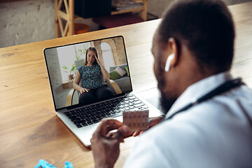 Image showing Young doctor working online with laptop, has online conference with colleague from workplace