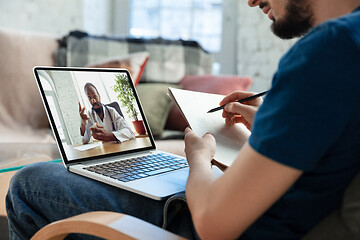 Image showing Man working from home, remote office concept. Young businessman, manager doing tasks with laptop, has online conference.