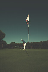 Image showing golf player hitting shot at sunny day