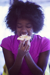 Image showing woman with afro hairstyle eating tasty pizza slice