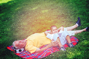 Image showing grandfather and child in park using tablet