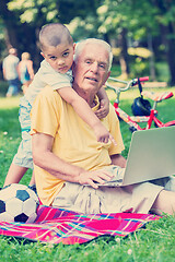 Image showing grandfather and child using laptop