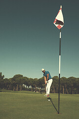 Image showing golf player hitting shot at sunny day