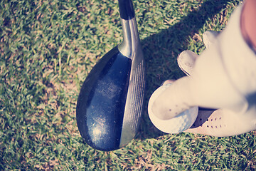 Image showing golf player placing ball on tee