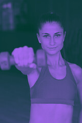 Image showing lifting some weights and working on her biceps in a gym