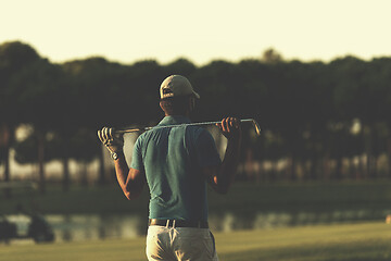 Image showing golfer from back at course looking to hole in distance