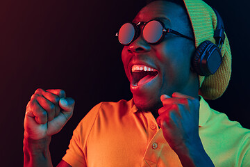 Image showing The young handsome hipster man listening music with headphones