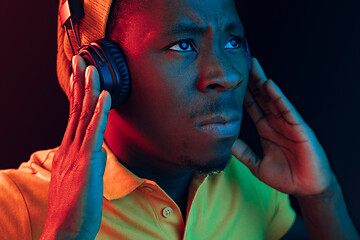 Image showing The young handsome hipster man listening music with headphones