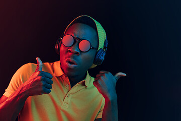 Image showing The young handsome hipster man listening music with headphones