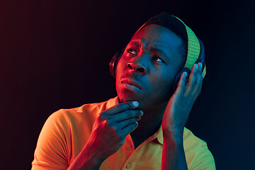 Image showing The young handsome hipster man listening music with headphones